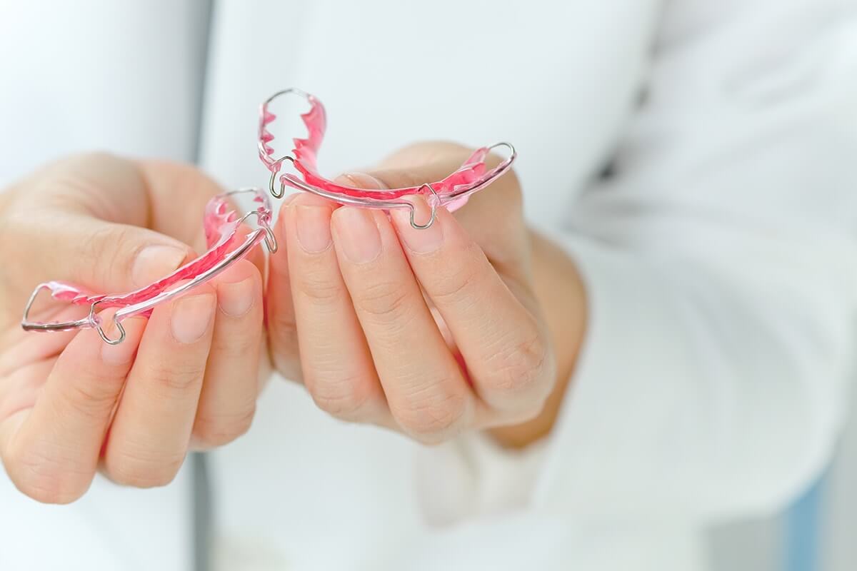 orthodontist explaining the importance of retainers after braces